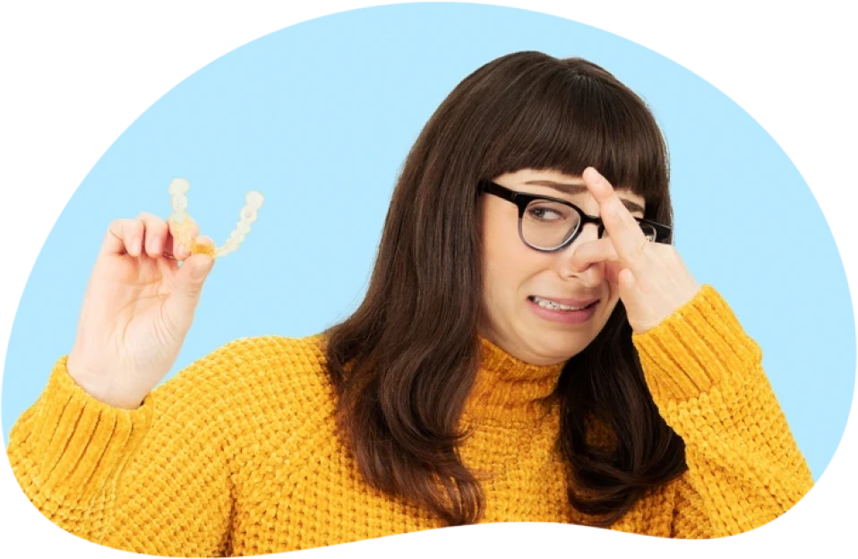 girl holding nose and aligner